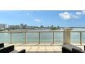 Wide balcony with glass railings overlooking beautiful water and city views; perfect for outdoor relaxation at 464 Golden Gate Pt # 702, Sarasota, FL 34236