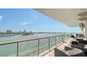 Spacious waterfront balcony perfect for entertaining, featuring comfortable seating and city views at 464 Golden Gate Pt # 702, Sarasota, FL 34236