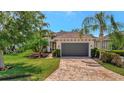 Attractive single Gathering home featuring a paved driveway, mature trees, and well-maintained lawn at 5009 Lake Overlook Ave, Bradenton, FL 34208