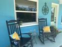 Inviting front porch with rocking chairs, a small table, and colorful pillows, perfect for relaxing at 534 Lewis St, Englewood, FL 34223