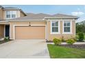 This home features a two-car garage and manicured landscaping, enhancing its curb appeal at 5520 Coachwood Cv, Bradenton, FL 34211
