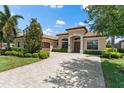 Lovely single-story home featuring manicured landscaping, a brick driveway, and an arched entryway at 5637 Arnie Loop, Bradenton, FL 34211