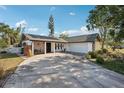 Beautiful house featuring a spacious driveway, well-kept lawn, and lovely stone accents at 5728 Whistlewood Cir, Sarasota, FL 34232