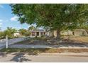 Charming home with a large tree and landscaped front yard at 5728 Whistlewood Cir, Sarasota, FL 34232
