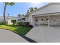A single-story home boasts a carport and awning-covered window, complemented by the lush front yard and a sunny, welcoming ambiance at 6087 Coral Way, Bradenton, FL 34207