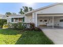 A cozy single-story home with a carport, awning-covered window, and lush greenery in the front yard provides an inviting curb appeal at 6087 Coral Way, Bradenton, FL 34207