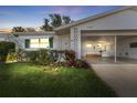 A cozy single-story home with a carport, awning-covered window, and lush greenery in the front yard provides an inviting curb appeal at 6087 Coral Way, Bradenton, FL 34207