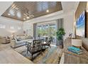 Bright living room boasts a decorative ceiling, comfortable seating, and sliding doors to the patio at 6228 Champions Row St, Bradenton, FL 34210