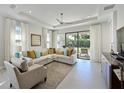 Bright living room with tile floors, a ceiling fan, and large windows that provide plenty of natural light at 6308 Plateau Ct, Bradenton, FL 34203