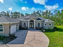 Stunning exterior of this well maintained house featuring a custom arched entrance and a long driveway at 6407 213Th E St, Bradenton, FL 34211