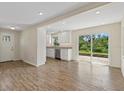 Bright, open-concept kitchen and living area boasts sleek wood floors, white cabinets and island, and natural light at 6718 68Th E Ave, Bradenton, FL 34203
