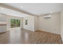 Bright, open-concept living area boasts sleek wood floors, a sliding glass door, and abundant natural light at 6718 68Th E Ave, Bradenton, FL 34203