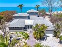 Beautiful coastal home showcasing multiple levels, lush landscaping, and panoramic ocean views at 8592 Hidden Lagoon Rd, Sarasota, FL 34242