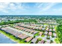 Scenic aerial view of a well-maintained community featuring multiple homes and a tranquil lake at 8721 Trattoria Ter, Sarasota, FL 34238