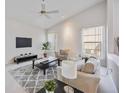 Comfortable living room with neutral colors, a ceiling fan, large windows, and a gray area rug at 8824 Havenridge Dr, Sarasota, FL 34238