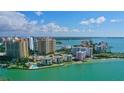 Stunning aerial view of luxury condos overlooking turquoise water, sandy beaches, and a vibrant city skyline at 99 Sunset Dr # 102, Sarasota, FL 34236