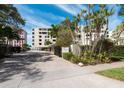 Inviting entrance to Lawrence Pointe Condominiums, showcasing a secure gate and lush tropical landscaping at 99 Sunset Dr # 102, Sarasota, FL 34236