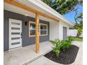 Eye-catching front entry with a modern door, natural wood accents, and professionally landscaped garden beds at 1050 55Th S Ave, St Petersburg, FL 33705