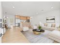 Bright living room with wood floors, light neutral furniture, and combined kitchen and dining areas at 1050 55Th S Ave, St Petersburg, FL 33705