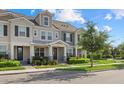 Attractive townhome exterior featuring neutral paint, dark shutters, and well-maintained landscaping under a blue sky at 12029 Cranston Way, Lakewood Ranch, FL 34211