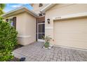 Close up shot of a house featuring a screen door entrance and brick paved driveway at 12592 Ryegrass Loop, Parrish, FL 34219