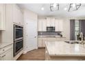 Bright kitchen features stainless steel appliances, double oven, custom cabinetry, and stone countertops at 12592 Ryegrass Loop, Parrish, FL 34219