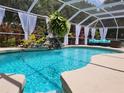 Inviting screened pool area with a cascading waterfall feature, tropical plants, and lounge seating at 12809 7Th Ne Ave, Bradenton, FL 34212