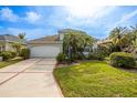 Charming home with a manicured lawn, mature palms, and a spacious two-car garage at 1322 Millbrook Cir, Bradenton, FL 34212