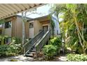 Exterior view of the condo with lush tropical plants and staircase to entry at 1720 Glenhouse Dr # Gl430, Sarasota, FL 34231