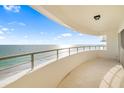 Expansive balcony overlooking the beach with neutral stone flooring and metal railings at 1750 Benjamin Franklin Dr # 6B, Sarasota, FL 34236