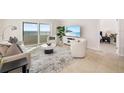 Comfortable living area featuring tile floors, neutral decor, and large windows with scenic ocean views at 1750 Benjamin Franklin Dr # 6B, Sarasota, FL 34236