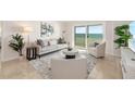 Bright living room with stylish furnishings and a sliding glass door to a balcony with ocean views at 1750 Benjamin Franklin Dr # 6B, Sarasota, FL 34236