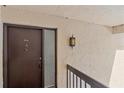 Close-up of the front door, number 204, and decorative light fixture, with textured wall at 2640 Clubhouse Dr # 204, Sarasota, FL 34232