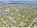 Aerial view of a neighborhood showing houses interspersed with trees and bisected with long straight roads at 27207 Treadmill Dr, Punta Gorda, FL 33955