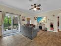 Inviting living room with wood-look floors, neutral tones, and a sliding glass door offering natural light and backyard access at 27207 Treadmill Dr, Punta Gorda, FL 33955