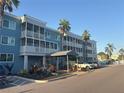 Exterior shot of blue condo building featuring palm trees, lush landscaping and resident parking at 2755 Coconut Bay Ln # 1313 3M, Sarasota, FL 34237