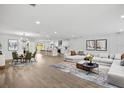Open-concept living room with kitchen, dining area, hardwood floors, modern decor, and natural light at 2881 48Th E Way, Bradenton, FL 34203