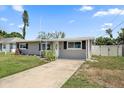 This is a single story home with neutral color scheme, dark shutters, and a well-manicured lawn at 3041 Teal Ave, Sarasota, FL 34232