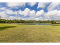 Expansive backyard with lush green grass and a tranquil lake view, perfect for outdoor activities and relaxation at 3607 Twin Rivers Trl, Parrish, FL 34219