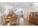 Inviting dining area and living room featuring hardwood floors, an eclectic light, and natural light at 3890 Wilshire Cir # 27, Sarasota, FL 34238