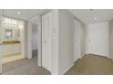 Hallway with carpeted and tiled floors leads to bathroom, bedroom and front door at 3950 Ironwood Cir # 206, Bradenton, FL 34209