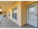Hallway with neutral colored walls and tiled floor leads to a door and large window at 3950 Ironwood Cir # 206, Bradenton, FL 34209