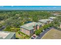 Aerial view showcases the beautifully maintained condo complex nestled amongst a serene pond and mature trees, creating a peaceful setting at 5242 Manorwood Dr Dr # 3A, Sarasota, FL 34235