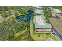 Overhead angle displays a well-maintained condo building next to a pond, surrounded by mature trees and lush landscaping at 5242 Manorwood Dr Dr # 3A, Sarasota, FL 34235