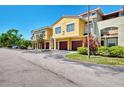 Sunny two-story townhomes with garages, landscaping, and a shared parking area at 5601 Bentgrass Dr # 10-105, Sarasota, FL 34235