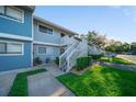 Charming two-story condo featuring a private patio area with green lawn and white stair railings at 6033 34Th W St # 132, Bradenton, FL 34210