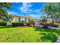 Beautiful home featuring lush green lawn, manicured bushes, and mature trees creating a serene curb appeal at 6729 45Th E Ter, Bradenton, FL 34203