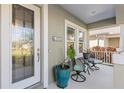 Inviting front porch with seating area, decorative plants, and leaded glass front door, ideal for relaxing at 6936 White Willow Ct, Sarasota, FL 34243