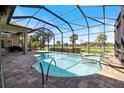 Screened-in pool and spa offer a refreshing escape with a view of the lush golf course at 72 Grande Fairway, Englewood, FL 34223