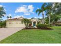 Charming single-story home featuring a three-car garage, a colorful front garden, and a well-manicured lawn at 7602 Partridge Street Cir, Bradenton, FL 34202